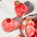 Pink lemonade with strawberries and cherries on a white surface