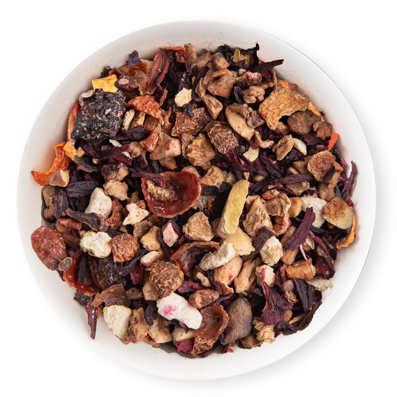 Assorted dried fruit and tea leaves in a white bowl on a white background