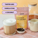 A stand-up pouch of tealish Coconut Cream Chai tea is shown on a pink plaid cloth beside a glass of iced coffee with foam, a small bowl of loose tea, and a cream pitcher. Text on the image reads 'TASTES LIKE: VANILLA CHAI + COCONUT'.