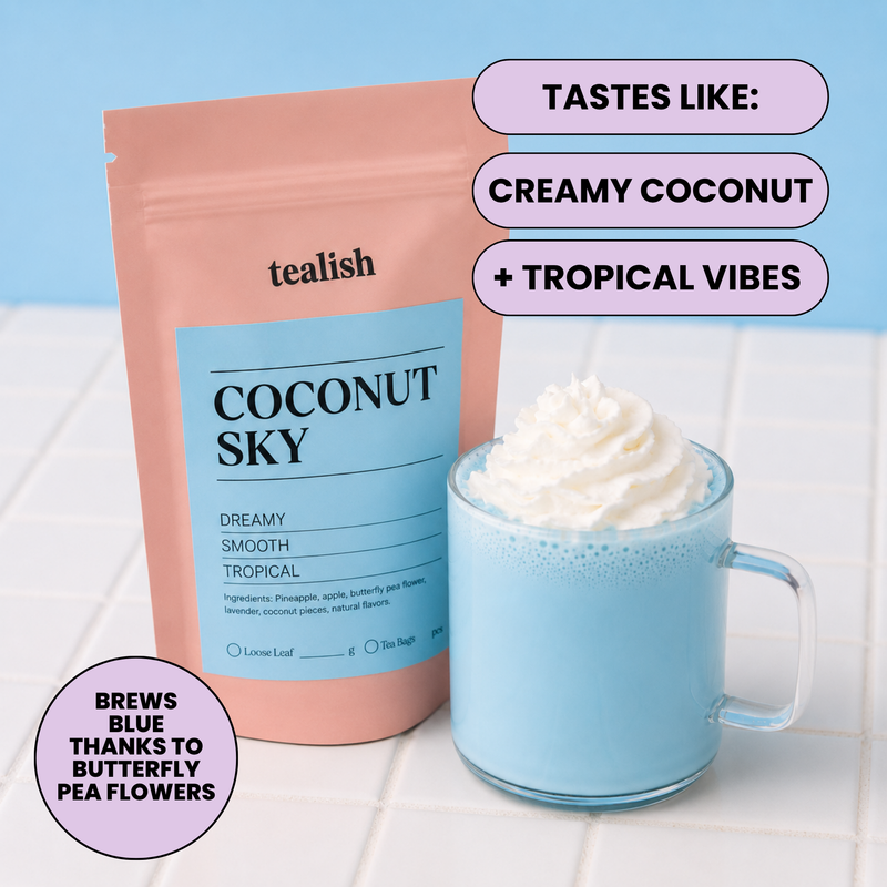 A stand-up pouch of tealish Coconut Sky coffee next to a light blue glass mug filled with whipped cream and a blue beverage. Text callouts say it tastes like creamy coconut and tropical vibes, and brews blue thanks to butterfly pea flowers.