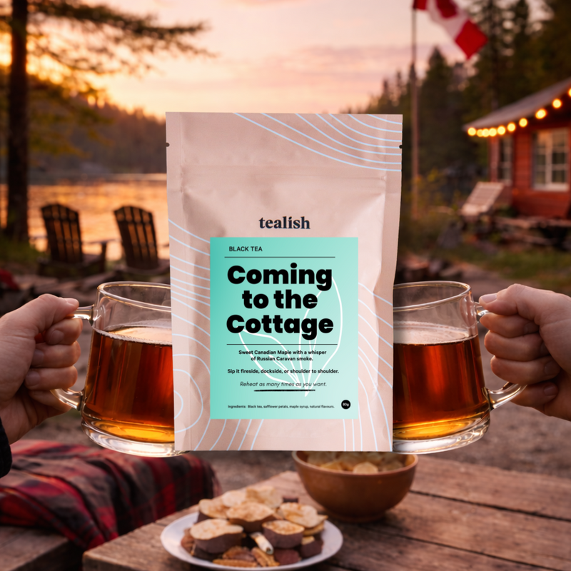 Tea packaging with 'Coming to the Cottage' text, two mugs of tea, and a scenic background with a lake and cabin.
