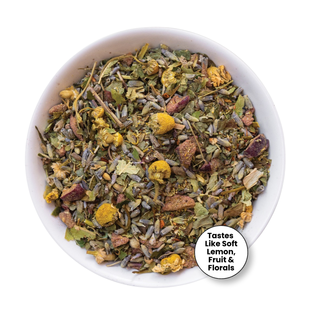 A top-down view of a white bowl filled with loose herbal tea blend, featuring dried flowers, leaves, and botanical pieces. A white circular badge in the lower right corner reads, 'Tastes Like Soft Lemon, Fruit & Florals.