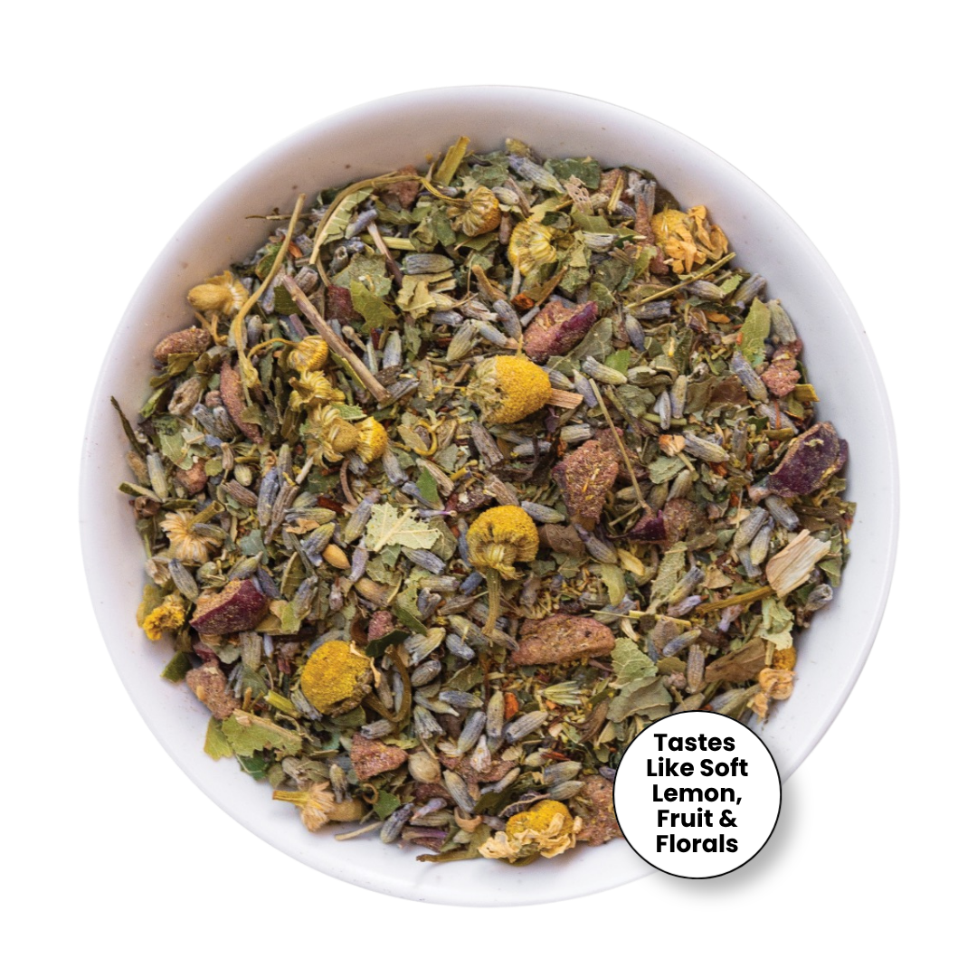 A top-down view of a white bowl filled with loose herbal tea blend, featuring dried flowers, leaves, and botanical pieces. A white circular badge in the lower right corner reads, &