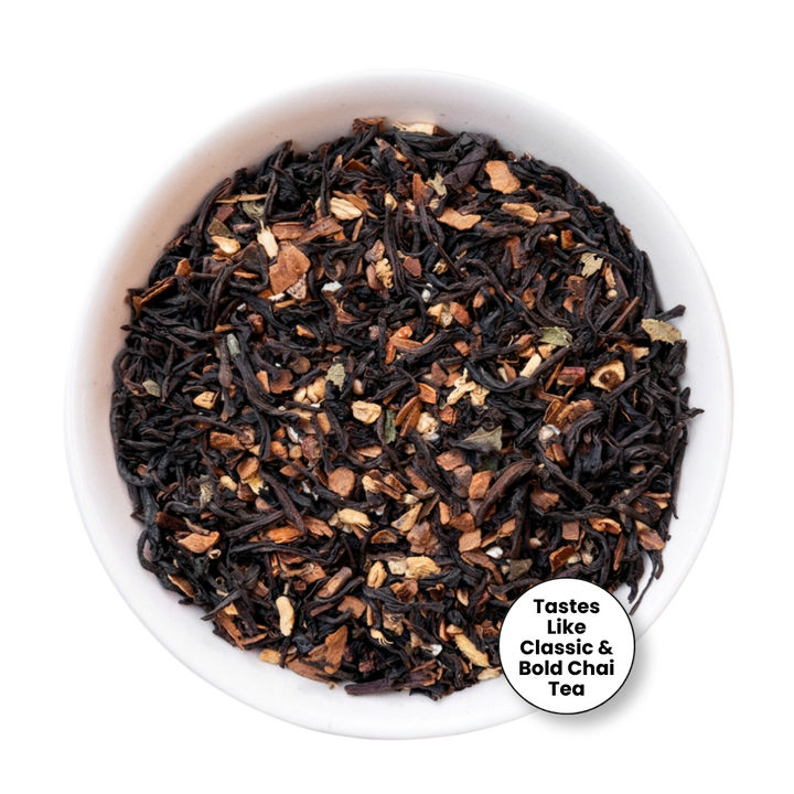A top-down view of loose-leaf tea in a white bowl, featuring dark black tea leaves mixed with brown and beige dried fruit and flower petals. A white circular badge in the bottom right corner reads &