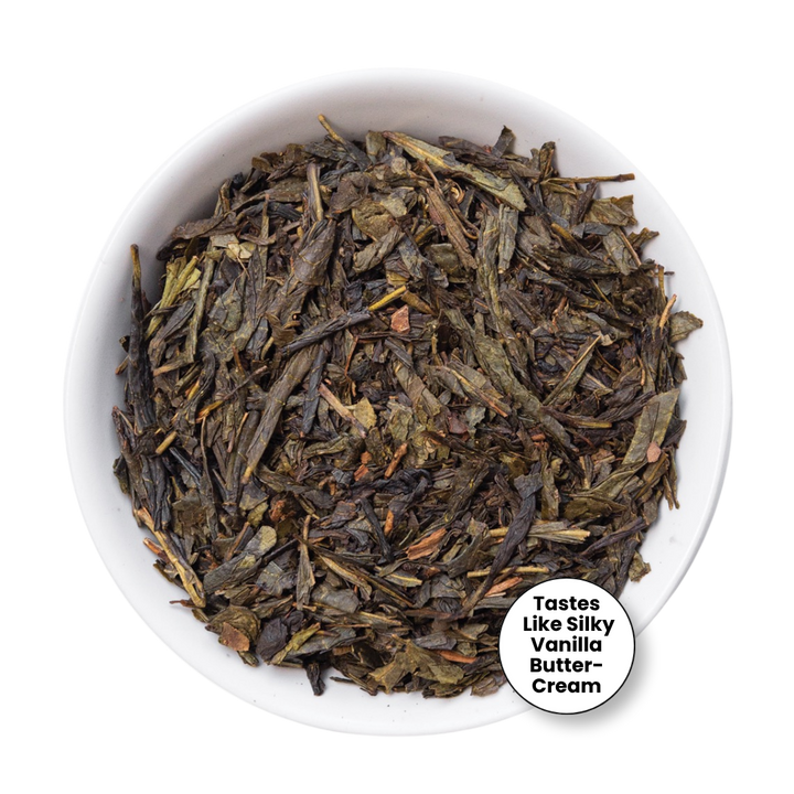 Loose leaf tea leaves in a small white bowl, with a circular label that reads &