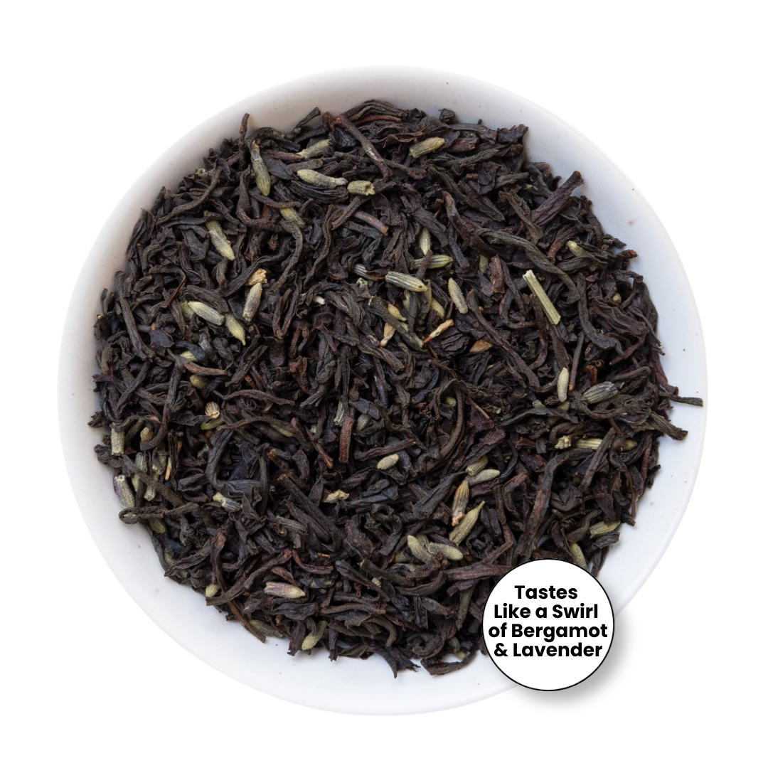 A top-down view of loose-leaf tea inside a white bowl, with a small circular label that reads &