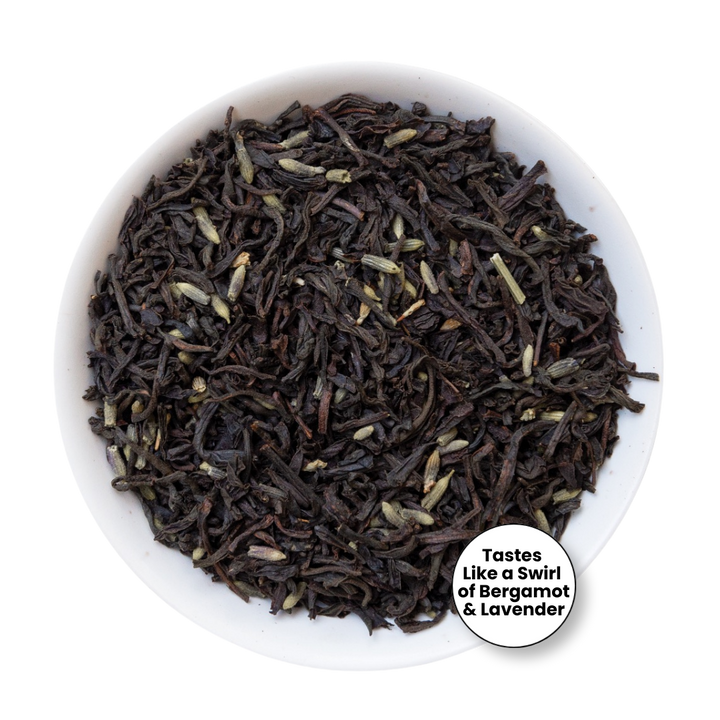A top-down view of loose-leaf tea inside a white bowl, with a small circular label that reads &