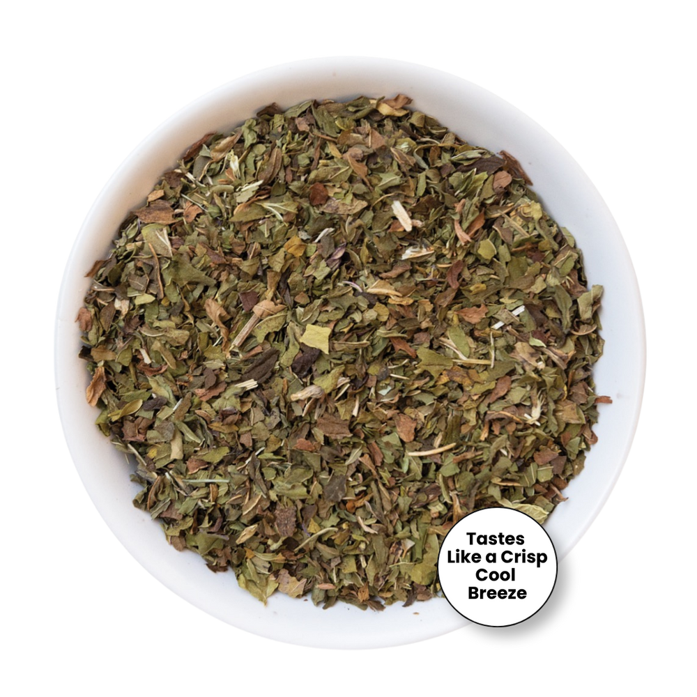 A top-down view of dried, chopped green herbs in a white bowl, with a circular badge in the bottom right corner that reads 'Tastes Like a Crisp Cool Breeze'.