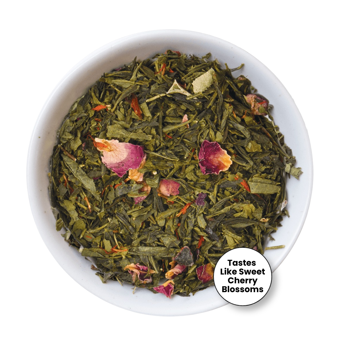 A top-down view of loose-leaf herbal tea in a white bowl, featuring green tea leaves mixed with dried pink and red flower petals. A circular badge in the bottom right corner reads &