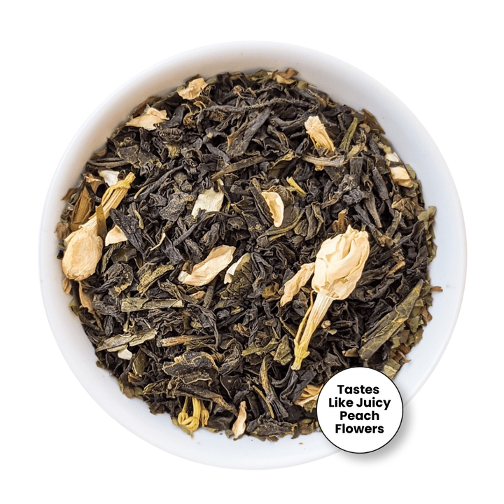 A top-down view of loose-leaf tea in a white bowl, featuring dark dried leaves mixed with pale peach flower petals. A circular badge in the lower right reads &