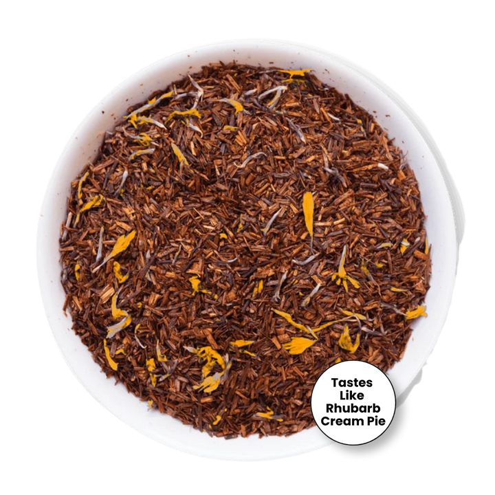 A top-down view of loose-leaf herbal tea in a white bowl, featuring dark brown rhubarb-like leaves with scattered bright yellow flower petals. A white circular badge in the bottom right corner reads &