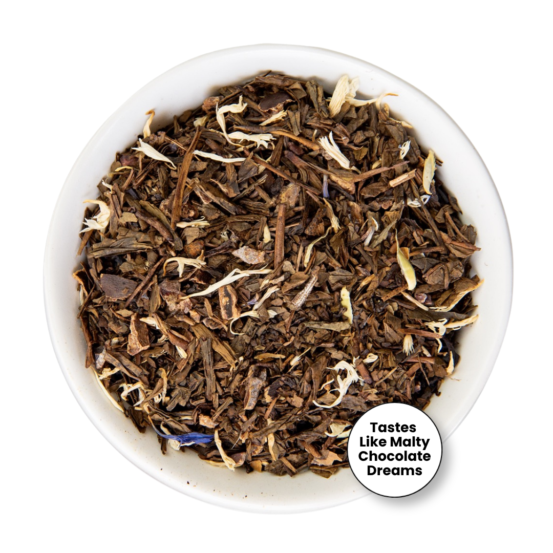 Loose leaf tea blend in a white bowl, featuring dark brown and medium brown pieces with small white flower petals and a hint of blue, with a circular badge reading &