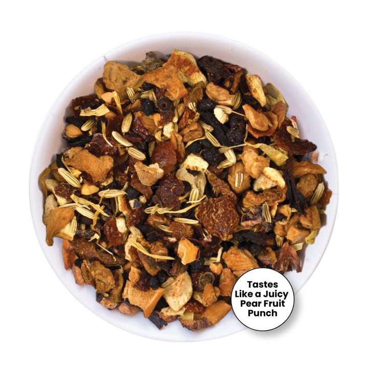 A top-down view of a white bowl filled with dried fruit and herb tea blend, featuring pieces of dried pear, apple, berries, and light tan herbal pieces. A white circular badge in the lower right reads &