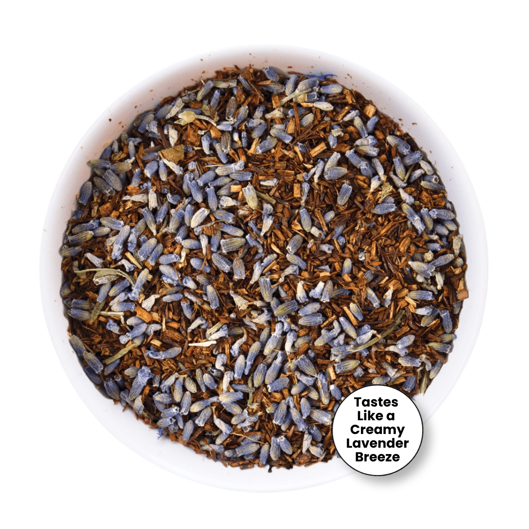 A top-down view of loose-leaf tea in a white bowl, featuring dried lavender buds mixed with brown wood chips. A white circular badge in the bottom right corner reads &