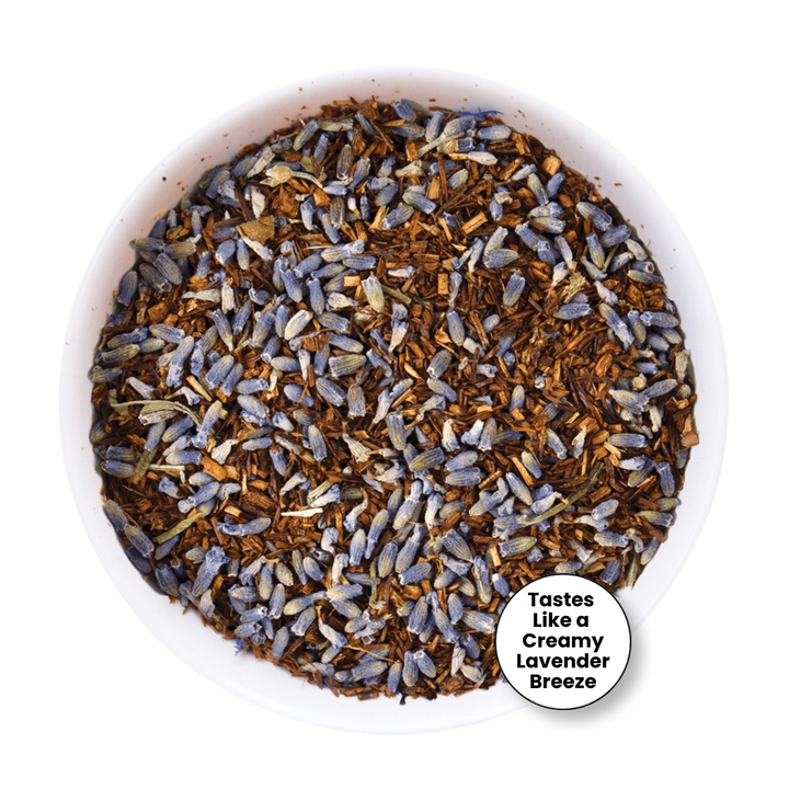 A top-down view of loose-leaf tea in a white bowl, featuring dried lavender buds mixed with brown wood chips. A white circular badge in the bottom right corner reads &