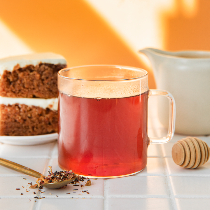 A picture of hot tea with a dessert on the side