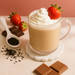 Glass of creamy beverage with whipped cream and a strawberry, surrounded by chocolate pieces and strawberries on a light pink background.