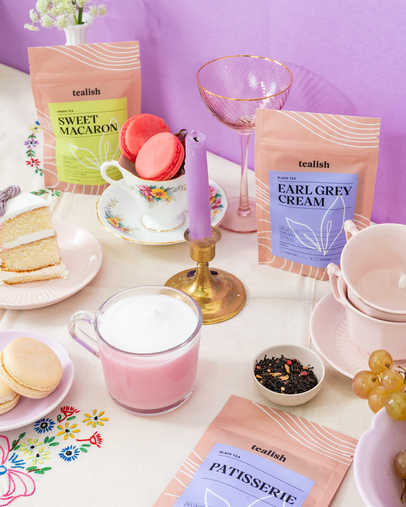Tea and pastries setup with teacups and cookies on a table.