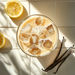 Glass of iced tea with milk and lemon slices and vanilla beans on a tiled surface