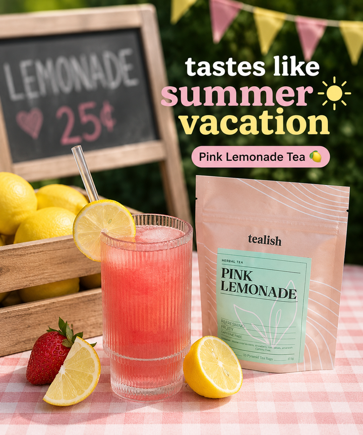 Pink lemonade tea with lemons, strawberries, and a chalkboard sign in a summery setting.