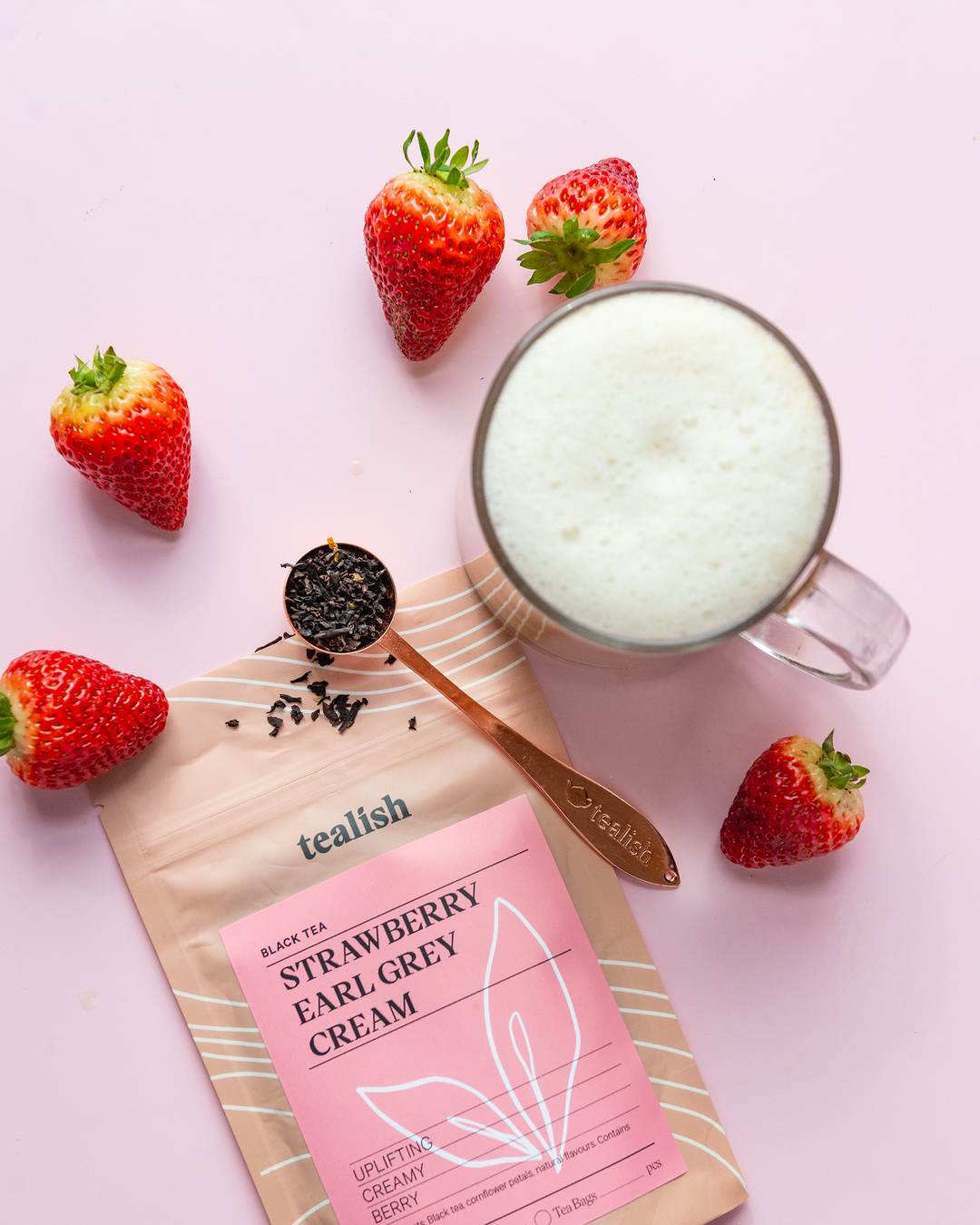 A picture of tea with strawberries on the side and a bag of Strawberry Earl Grey Cream tea