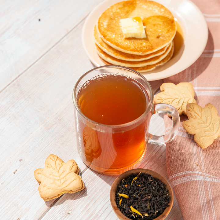 A picture of a hot drink with pancakes and biscuits on the side