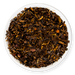 Dry tea leaves in a white bowl on a white background